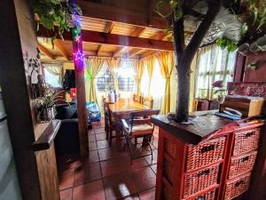 a living room with a table and a tree in it at CASA FAMILIAS muy cerca PLAYA Y Av3 in Villa Gesell