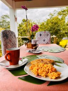 a table with a plate of food and a cup of coffee at Cabaña Campestre Santa Helena in Choachí