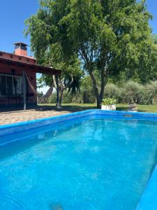 a blue swimming pool in front of a house at Los Huesos 2 in Chascomús