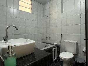 Un baño con bañera, inodoro y lavabo. en Casa Estrela Room, en Salvador 37 fotos más