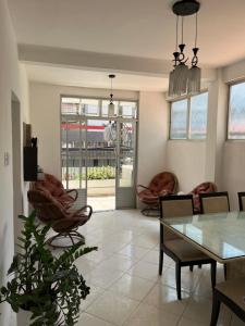 Una sala de estar con una mesa de cristal y sillas. en Casa Estrela Room, en Salvador