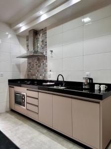 a kitchen with a sink and a stove at Apartamento Palmeira in Formosa