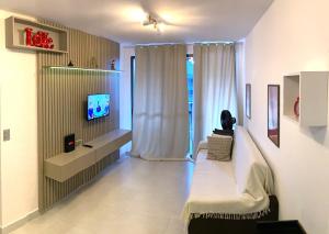 un salon avec un canapé et une télévision dans l'établissement Ponta Verde 250m praia I Feirinha do Artesanato I Piscina I Academia, à Maceió