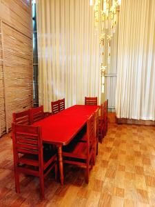 a red dining room table with wooden chairs and a red at KODAI RiYA PARADISE in Kodaikānāl
