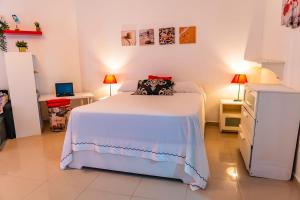 una camera con letto bianco e cassettiera di OCEANPARADISE to you ALBATRO l Y ll a Juan Dolio