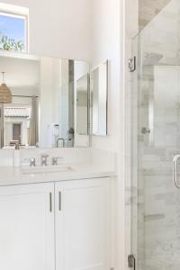 Un baño blanco con lavabo y ducha. en Luxury and comfort throughout Pool Spa Putting Green, en La Quinta