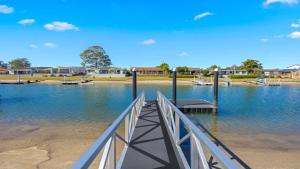 a dock in the middle of a body of water at Hibbard Waterfront Escape in Port Macquarie +9 photos