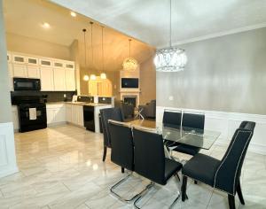 a kitchen and dining room with a glass table and chairs at Cozy 3BR Home Near ATL Airport in Fairburn