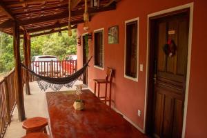a porch with a hammock on a house at Chalé Mascarenhas in Ibicoara