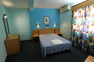 a room with a bed and a blue wall at Hotel São Lourenço in Samora Correia +18 photos