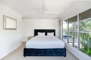 a bedroom with a bed and a large window at Riverside Sanctuary at Loch Mews in Noosaville +37 photos