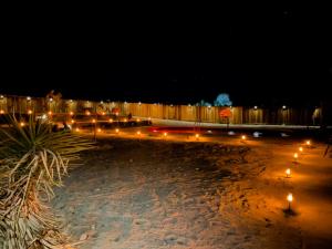 a fence with lights on a beach at night at Private Home - Heated Saltwater Pool, BBQ, Pro Pool Table, Horseshoes, Darts, Cotton Bedding, Half Acre - The Joshua Tree Forest - Pool Heat Optional in Twentynine Palms +63 photos