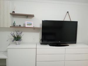 a flat screen tv sitting on top of a white dresser at LOFT NOVO CONFORTÁVEL in Sorocaba