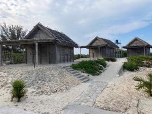 a group of three wooden huts on a beach at Vazaha Vezo in Andavadoaka