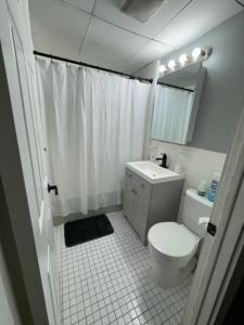 a bathroom with a toilet and a sink and a mirror at Queen Bed Condo by the Beach in Lynn
