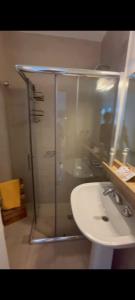 a bathroom with a glass shower and a sink at Condominio Monte Molinos - La Vista in Villa Ciudad de America