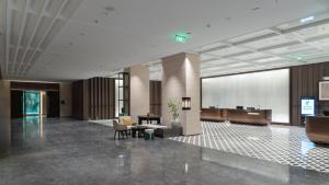 a lobby of a hotel with a waiting area and a podium at Holiday Inn Liaoyuan City Center by IHG in Liaoyuan