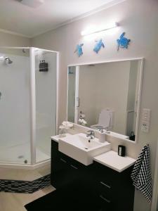 bagno con lavandino, doccia e specchio di Lakaz a Omokoroa Altre 12 foto
