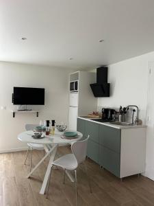 a kitchen with a table and chairs in a kitchen at Studio chic et cocon proche de Disney in Lagny +10 photos