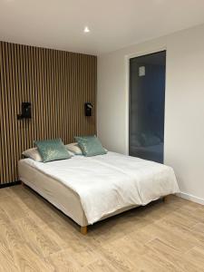 a bedroom with a large white bed with two pillows at Studio chic et cocon proche de Disney in Lagny