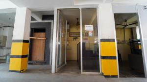 an entrance to a building with yellow and black columns at Vangal Nest PSG IN in Coimbatore +32 photos