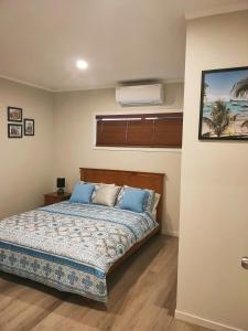 una camera da letto con un letto con cuscini blu di Lakaz a Omokoroa