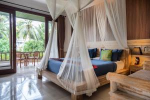 a bedroom with a bed with a mosquito net at Alam Terrace Cottages in Ubud +37 photos