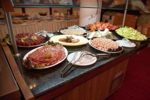 ein Buffet mit vielen Tellern voller Speisen auf einer Theke in der Unterkunft The Vineyards Boutique Hotel & SPA in Aheloy