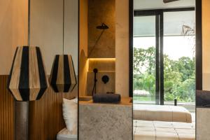 two views of a bedroom with a bed and a window at Villa Famara Pererenan, Canggu by Blacksand in Tumbak Bayuh