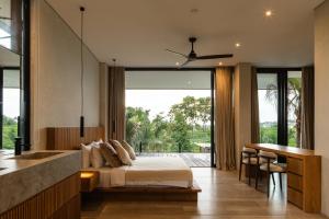 une chambre avec un lit et un bureau et une cuisine dans l'établissement Villa Famara Pererenan by Blacksand, à Tumbak Bayuh