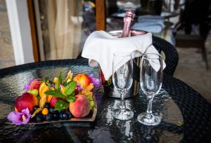 ein Tisch mit einem Teller Obst und einem Weinglas in der Unterkunft The Vineyards Boutique Hotel & SPA in Aheloy