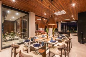 a dining room with a long table and chairs at Villa Famara Pererenan, Canggu by Blacksand in Tumbak Bayuh