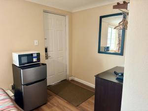 a room with a kitchen with a microwave and a door at Gratiot View Motel in Saginaw