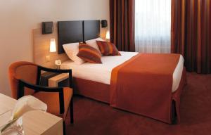 ein Hotelzimmer mit einem großen Bett und einem Stuhl in der Unterkunft Hotel Suisse in Genf