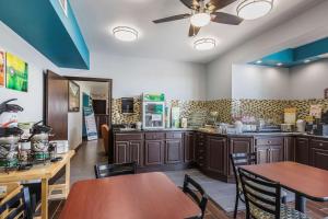 a kitchen with wooden tables and chairs in a restaurant at Quality Inn Charleston - Sikeston in Charleston