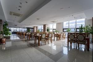仁川市Browndot Hotel Incheon Songdo的用餐室设有桌椅和窗户。
