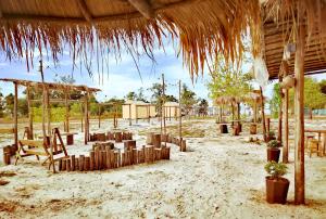 une plage avec un parasol en paille, des chaises et des tables dans l'établissement Mai Rut Beach Eco Camping, à Ban Nong Wiwat 56 autres photos