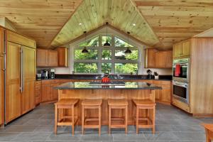 キリングトンにあるVistas 92 - 4-Bedroom Luxury Ski On Ski Off Home with Hot Tub, Views, Amenity Centerの大きなキッチン(木製キャビネット付)