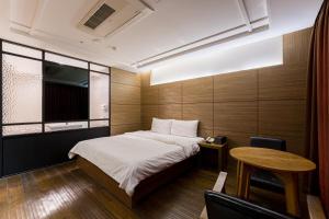 仁川市Browndot Hotel Incheon Songdo的一间有一张床和一张桌子的小房间