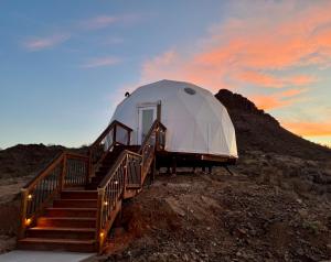 a large dome tent on a hill with stairs at Stargazer- The Dome Life in Anthem
