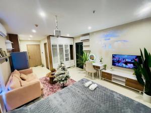 un salon avec un canapé et une télévision à écran plat dans l'établissement Linh Linh House - Vinhomes Ocean Park, à Gia Lâm Pho
