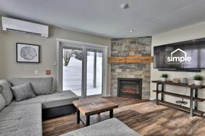 a living room with a couch and a fireplace at The Forest Fun Suite - 2RM-2BA Condo, Pool, Bus, King Bed, 2 Sofa Beds, Fireplace, Ski Rental Deals in Killington