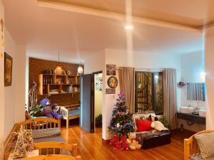 a living room with a christmas tree in a room at BắpHouseHomestay in Da Lat