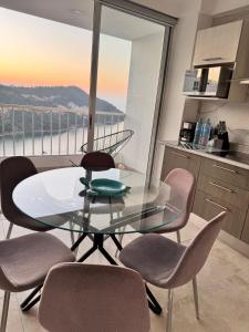 a glass table and chairs in a kitchen with a view at Apartamento Blue Acapulco Diamante in Acapulco +39 photos