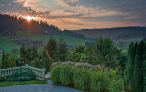 a bench in a garden with the sunset in the background at Willa Wuja Sama in Zawóz