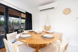 Un comedor con mesa y sillas de madera. en The Beachwood Nest, en Cable Beach