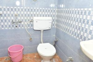 a bathroom with a toilet and a sink and a bucket at The Hidden Cove in Bhīm Tāl +51 photos