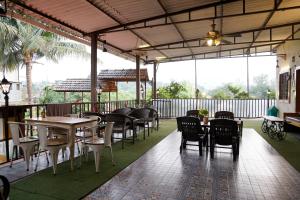 un restaurant en plein air avec des tables et des chaises ainsi qu'une terrasse dans l'établissement Hashtag Travellers By Mody Stays, à Lonavala