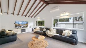 una sala de estar con 2 sofás de cuero negro y una mesa. en 150South, en Culburra Beach