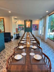 a long long table in a room with chairs at บ้านริมเนิน รีสอร์ท งาว in Ngao